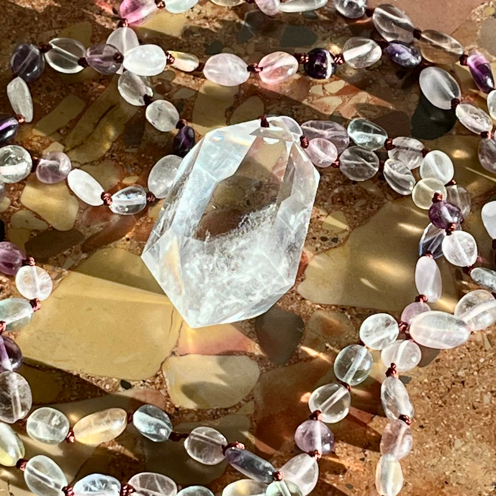 Hand-knotted necklace with fluorite and rock crystal tip